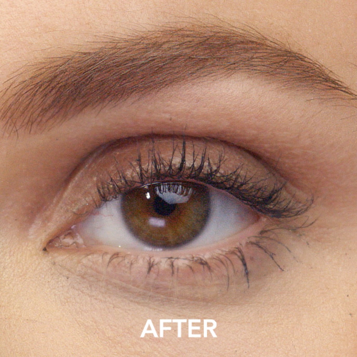 Close up of a woman looking over her shoulder holding a bottle of Lumify cleansing water